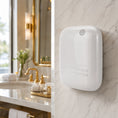 Charger l'image dans la visionneuse de la galerie, Difusor nebulizador Bluetooth compacto 400ml blanco Serviaroma Shop instalado en pared de mármol en baño de hotel de lujo con grifería dorada