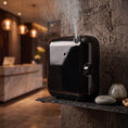 Cargar la imagen en la vista de la galería, Difusor nebulizador Bluetooth compacto 100ml negro Serviaroma Shop en funcionamiento con vapor de fragancia en recepción de hotel boutique