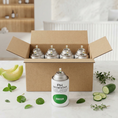 Cargar la imagen en la vista de la galería, Pack aerosol ambientador profesional aroma Green 250ml Serviaroma Shop, con melón, pepino y hierbas frescas sobre encimera de mármol blanco
